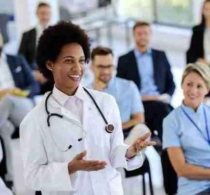 Happy black doctor talking to a presenter during an educational